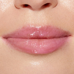 Affichage du gloss Too Faced avec des fraises en arrière-plan