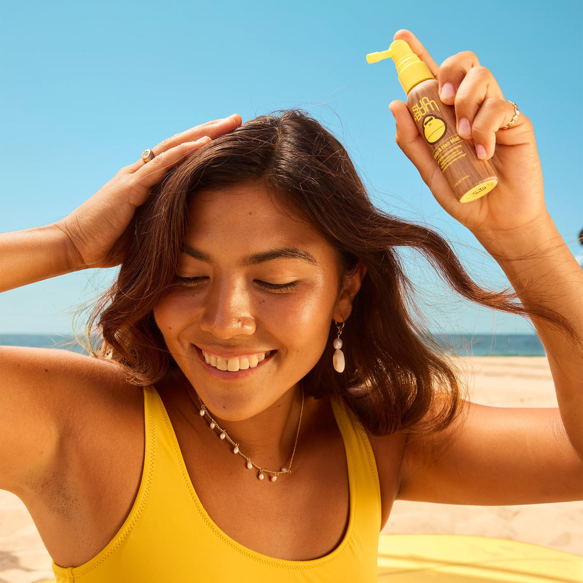 Application de la brume solaire Sun Bum sur le cuir chevelu