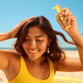 Application de la brume solaire Sun Bum sur le cuir chevelu