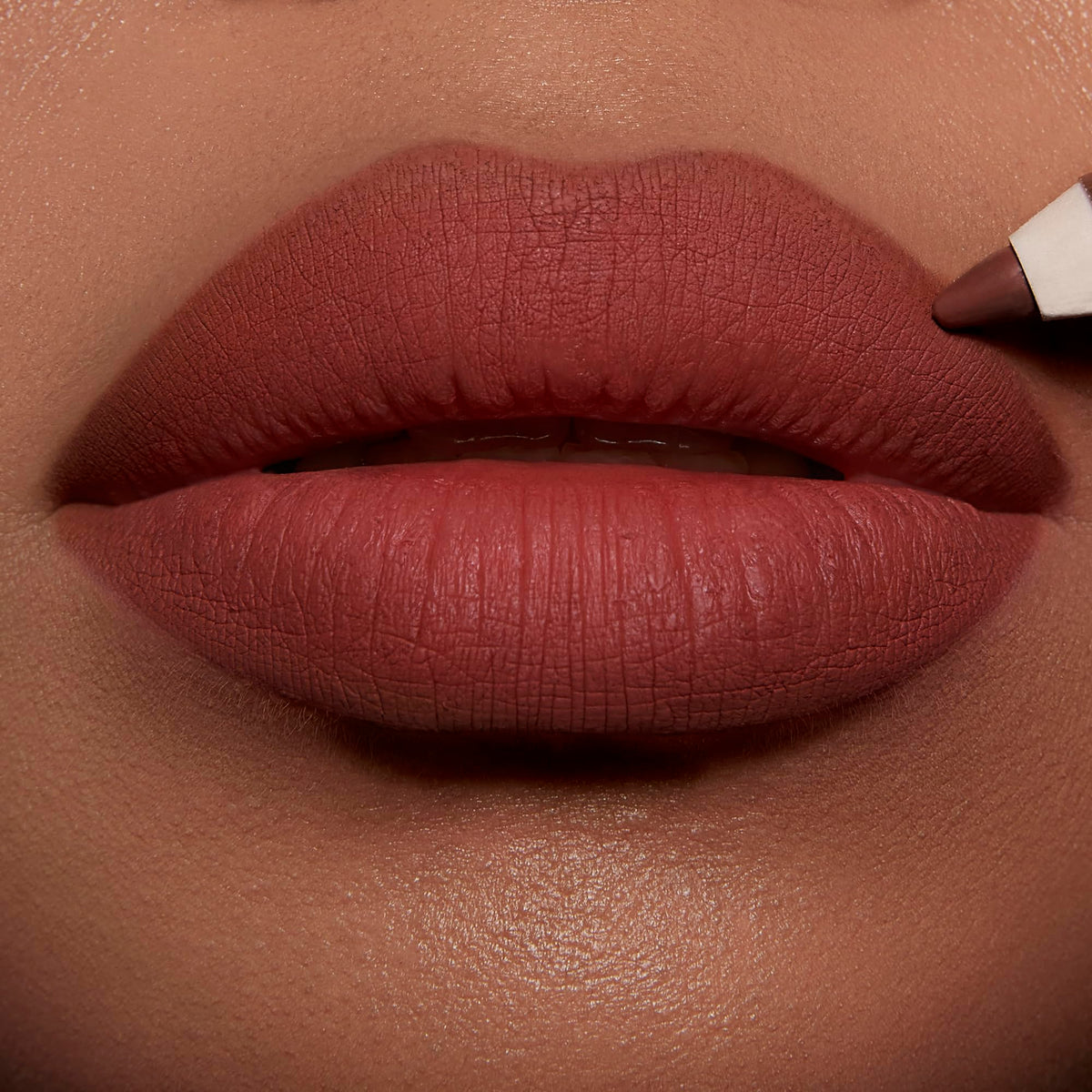 Application du crayon à lèvres Charlotte Tilbury sur une modèle