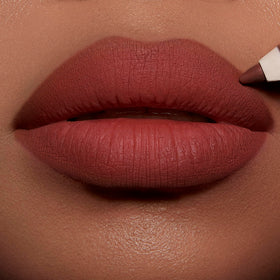 Application du crayon à lèvres Charlotte Tilbury sur une modèle