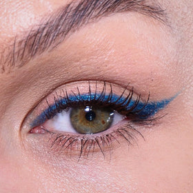 Application du crayon eyeliner bleu glacé sur la main