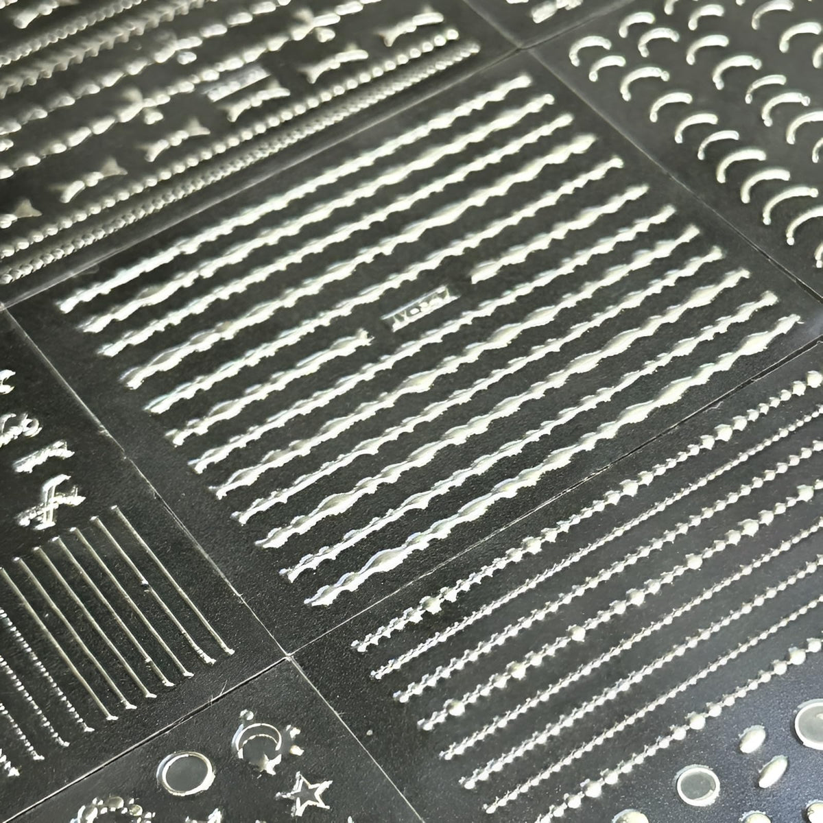 Autocollants d'ongles argentés sur des mains décorées