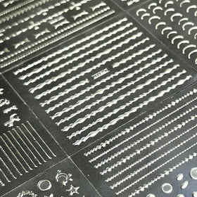 Autocollants d'ongles argentés sur des mains décorées
