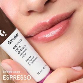 Baume Glossier Balm Dotcom au café mocha dans une trousse de beauté