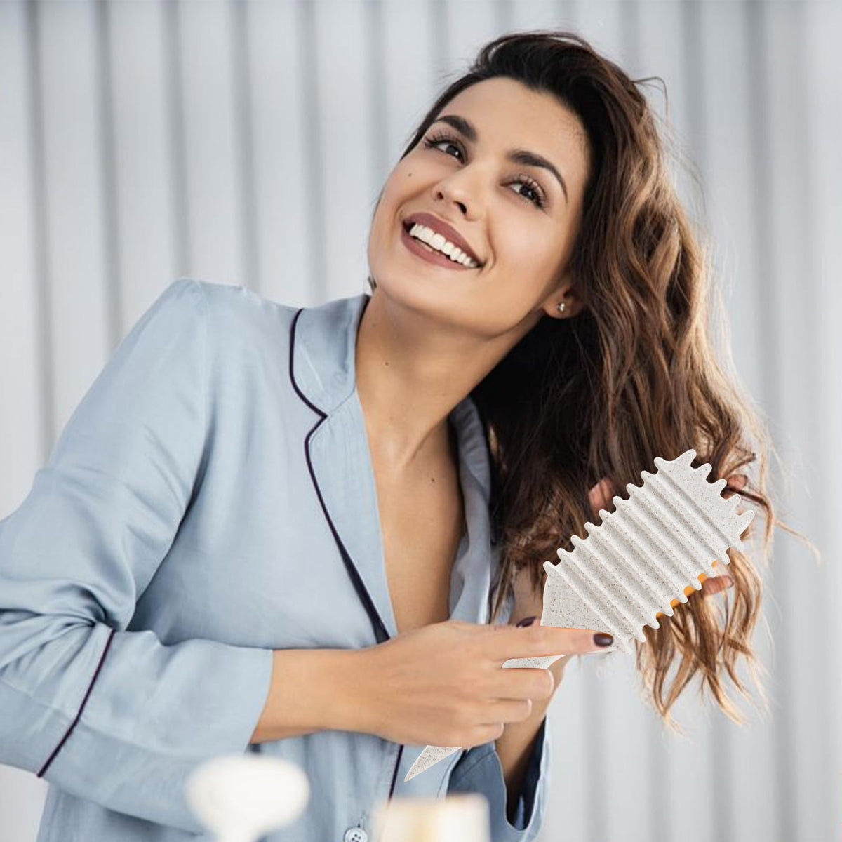 Brosse à cheveux bouclés UVZNUMG en action lors de l'application de produit