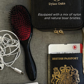 Brosse à cheveux Denman Cushion posée sur un fond blanc