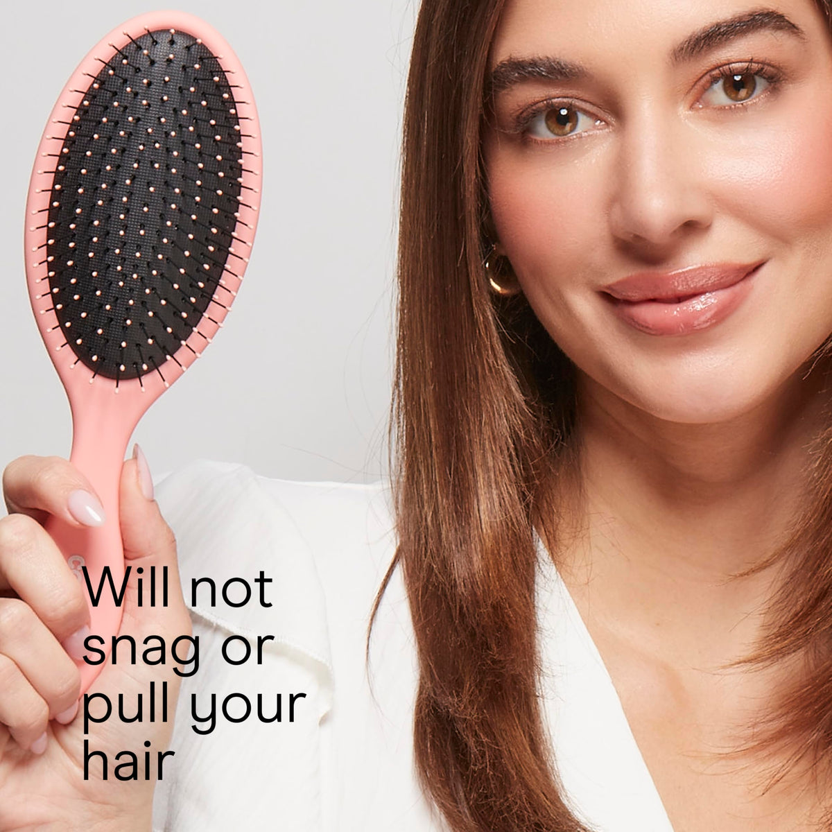 Brosse démêlante Conair en main avec cheveux noirs