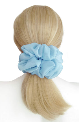 Détail de l'élastique à cheveux bleu clair avec ruban argenté.