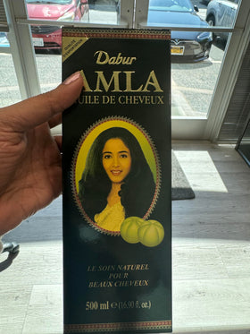 Détail de l'huile de cheveux Amla Dabur sur une surface en bois
