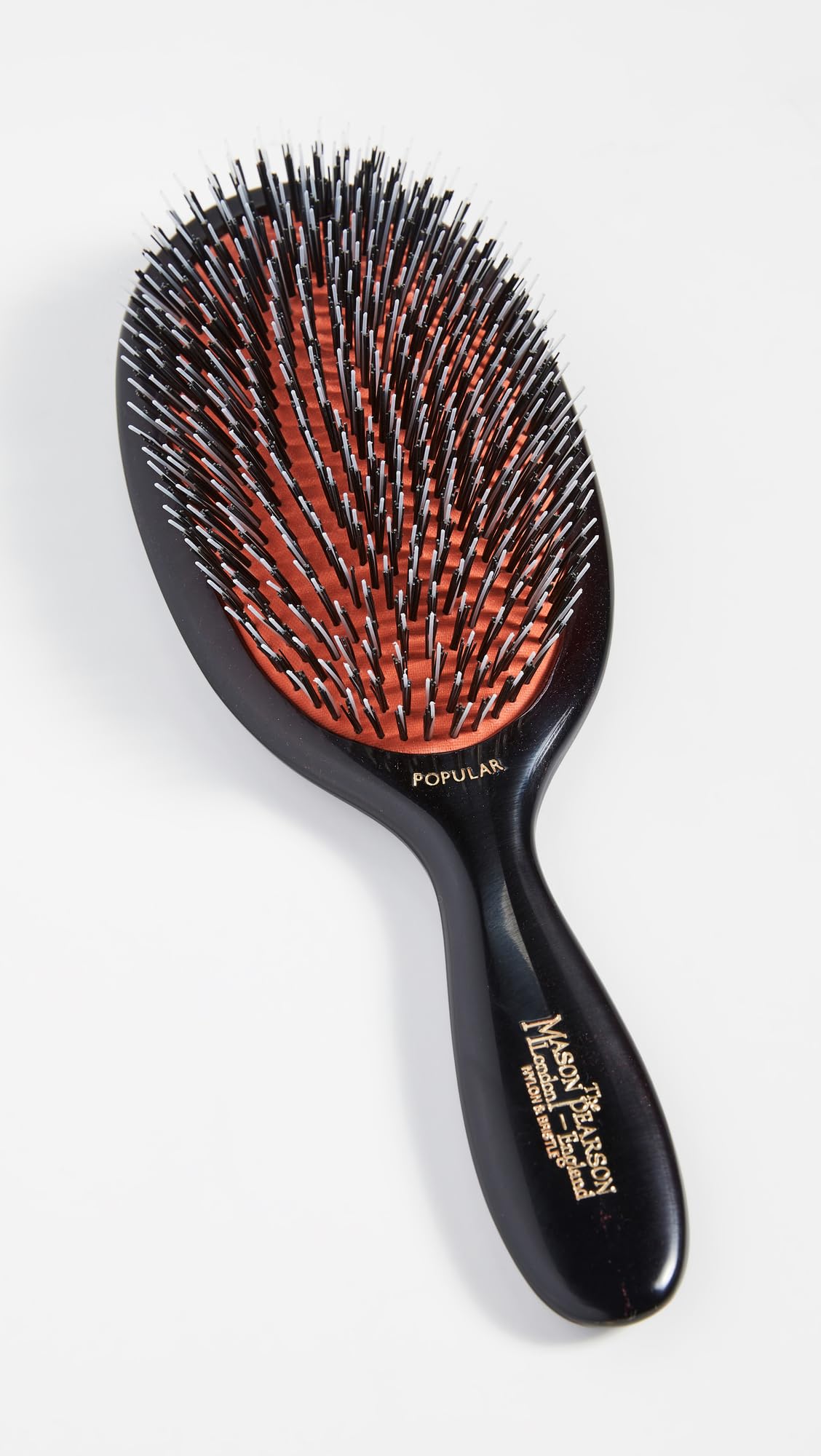 Détails de la brosse à cheveux Mason Pearson montrant le manche en plastique poli
