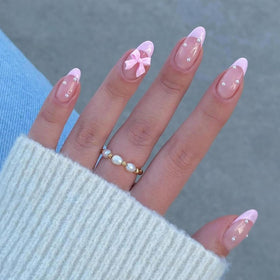 Faux ongles pressés rose avec design en nœud, vue de face