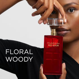 Flacon d'Eau de Parfum Elizabeth Arden Red Door avec fleur en arrière-plan