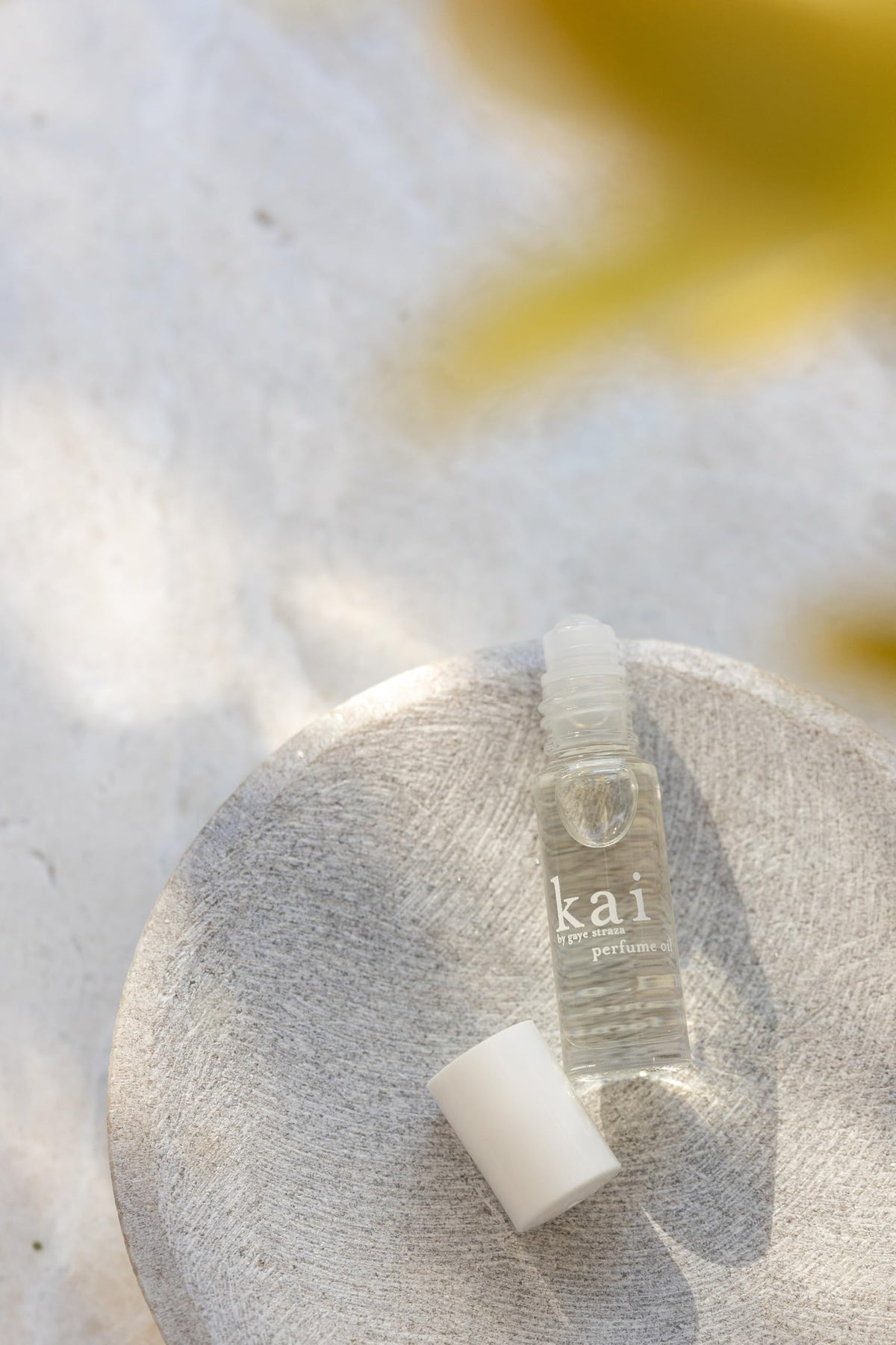 Flacon de parfum huile kai à la gardénia sur un fond floral