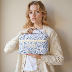 HBselect Trousse de Maquillage Matelassée sur une table avec un fond floral
