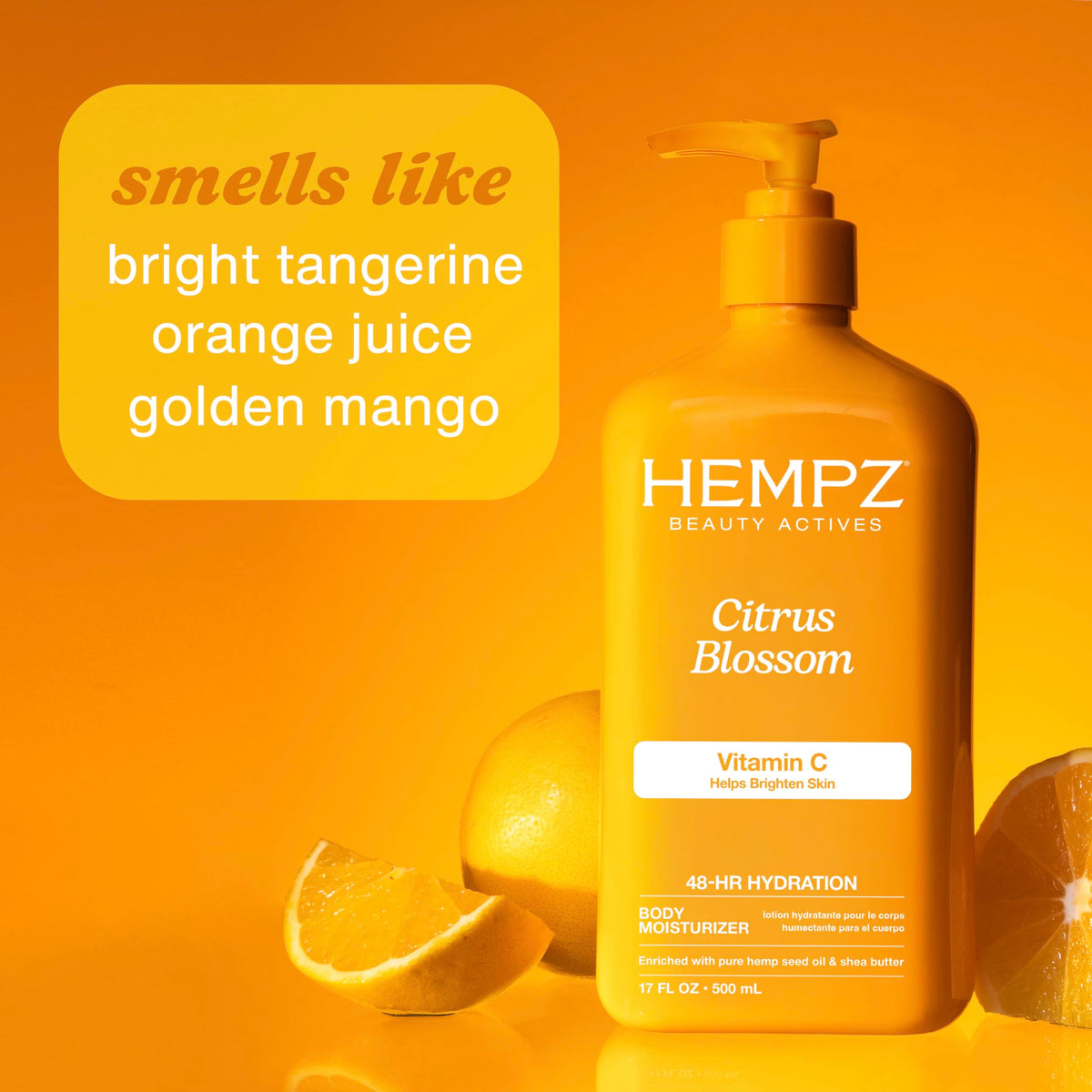 Hempz Lotion Corporelle Citrus Blossom sur une table avec des oranges