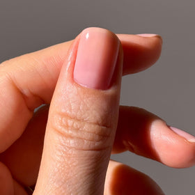 LONDONTOWN kur Perfecting Nail Veil #4 Dusty Rose Tint sur une table