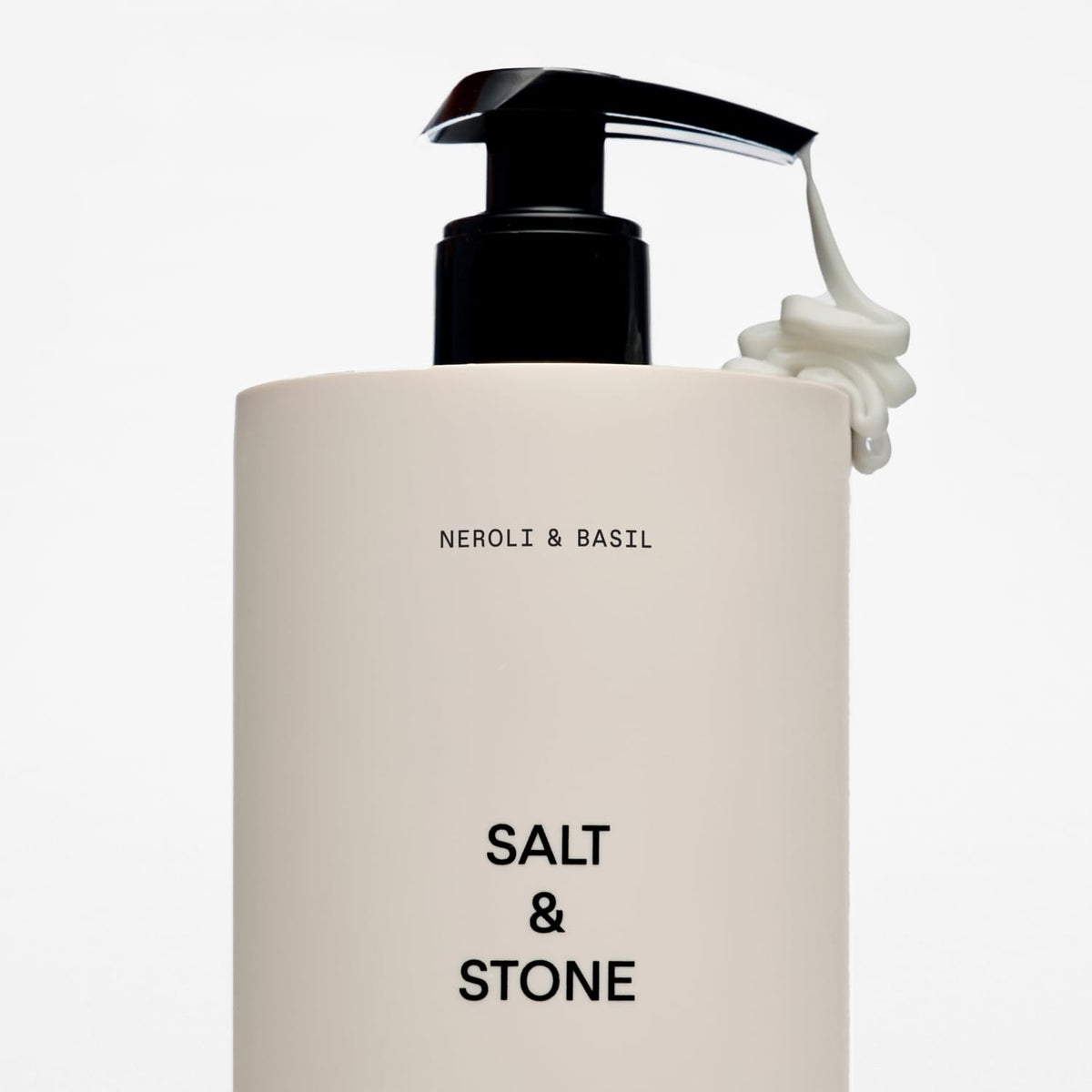 Lotion corporelle Salt & Stone près de plantes vertes