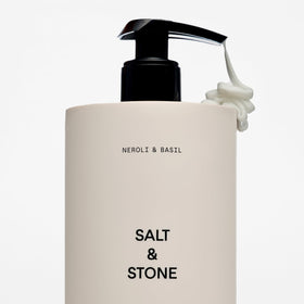 Lotion corporelle Salt & Stone près de plantes vertes