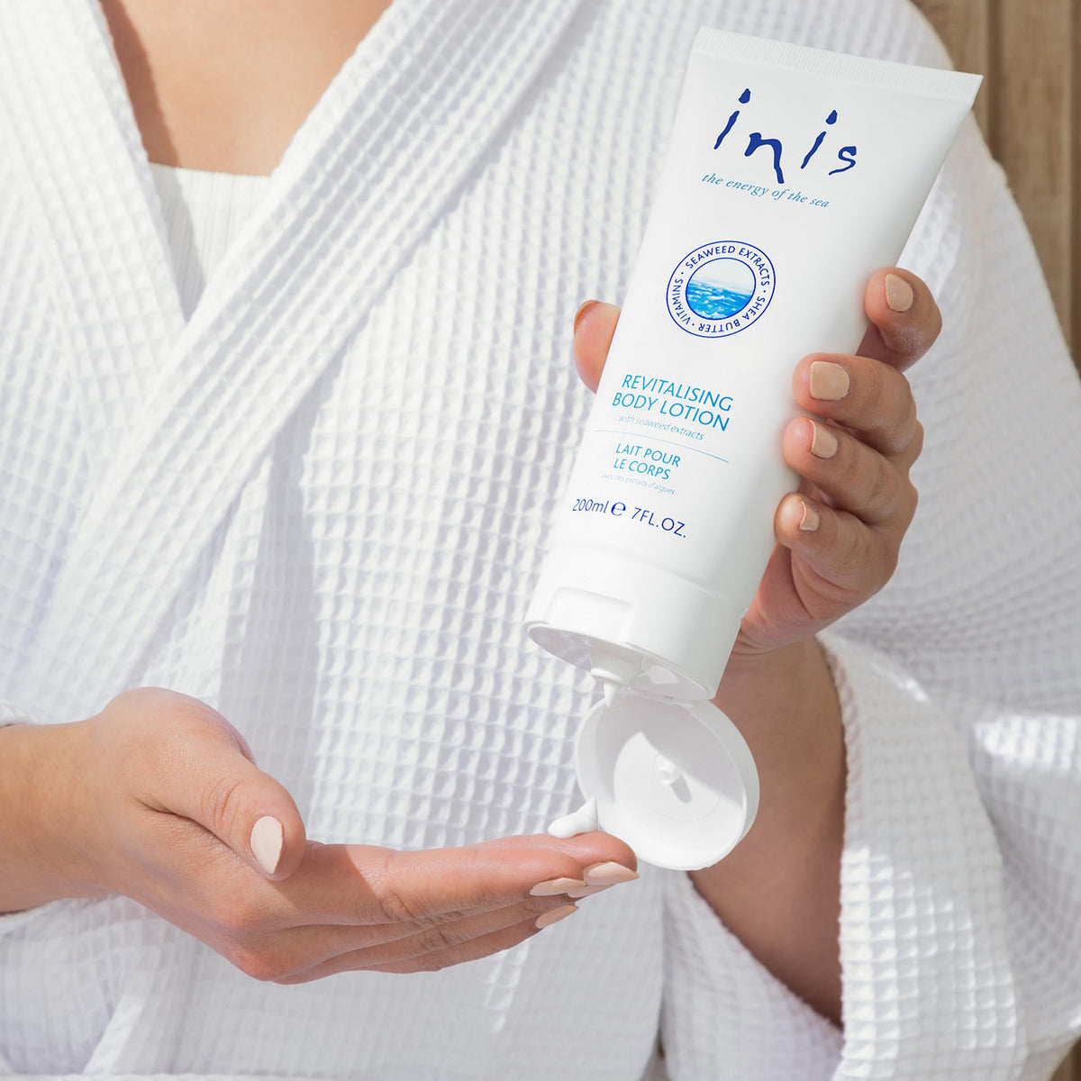 Lotion Inis 240g sur une table avec des éléments marins