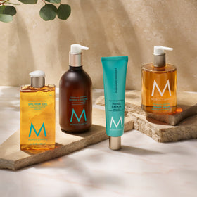 Lotion Moroccanoil avec des fleurs en arrière-plan