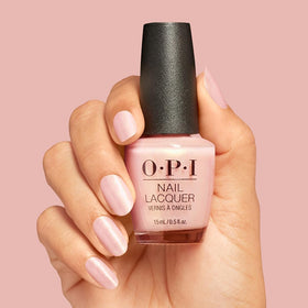 Main appliquant le vernis OPI Reoccurin' Gleam sur des ongles