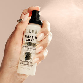 Milani Spray Fixateur Solaire SPF 30 à côté de produits de maquillage
