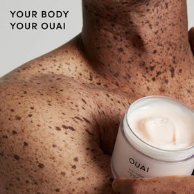 OUAI Crème Corporelle avec ingrédients naturels en arrière-plan