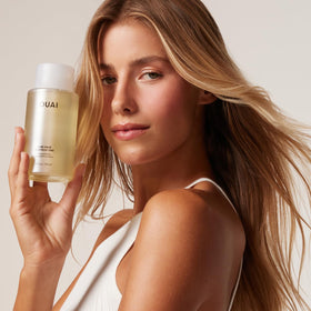 OUAI Shampoo Épaississant à côté d'un flacon de conditionneur