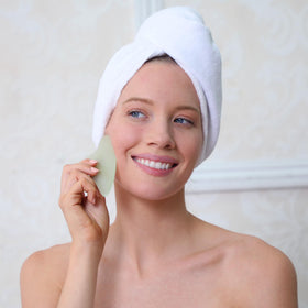 Outil Gua Sha en jade sur un fond de marbre