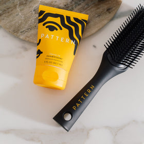 PATTERN Leave-In Conditioner 110g avec texture crémeuse sur un doigt