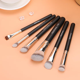 Pinceau TEOYALL 270S sur un fond de maquillage avec divers produits
