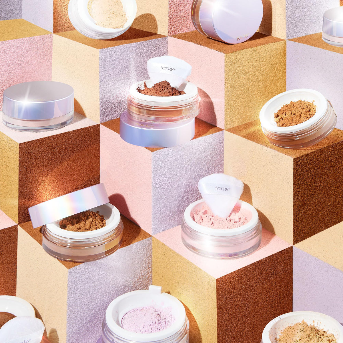 Poudre fixante tarte à côté de produits de maquillage