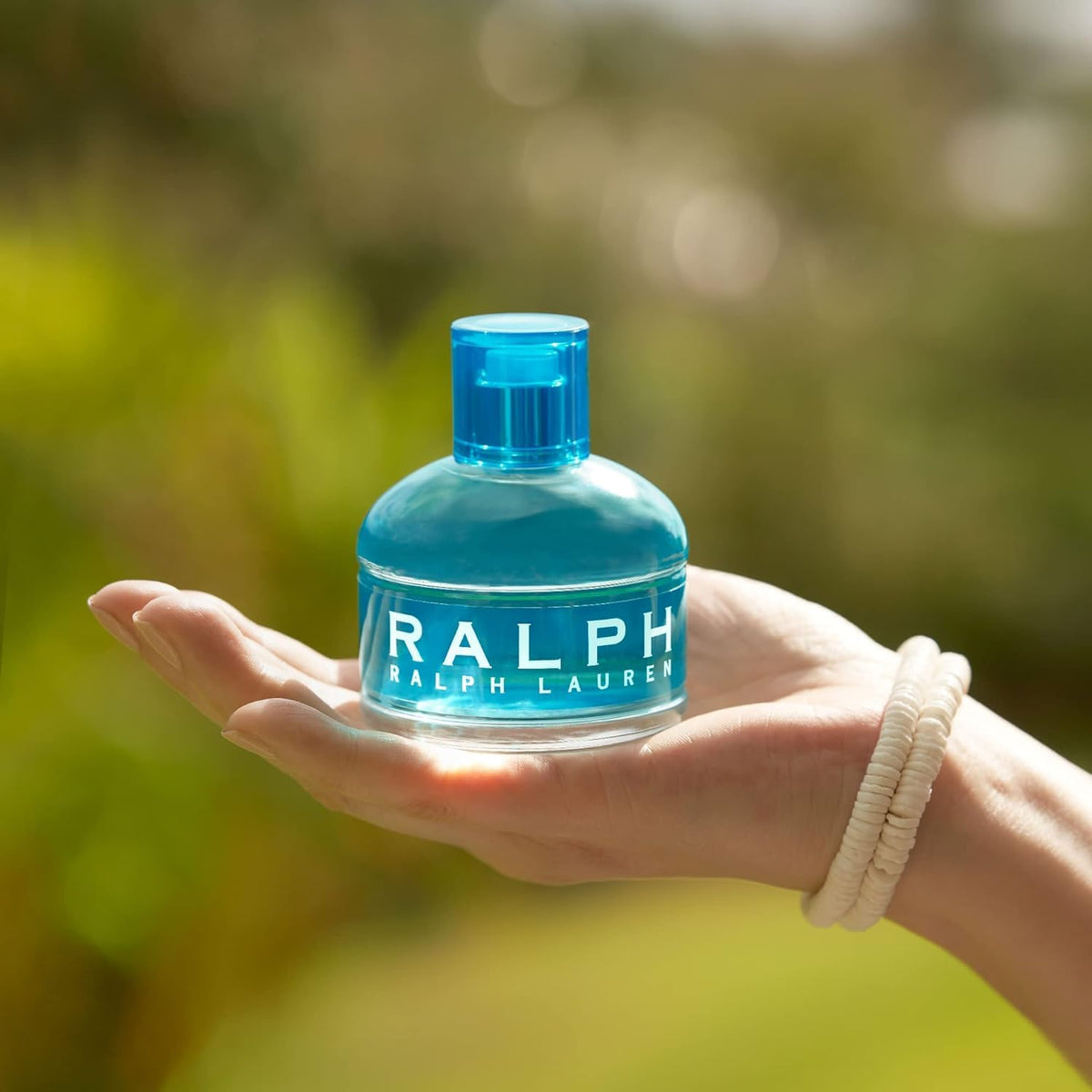 Ralph Eau de Toilette Femme 100ml sur une table avec fleurs