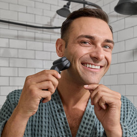 Rasoir électrique MANSCAPED The Chairman™ Plus sur une table de salle de bain