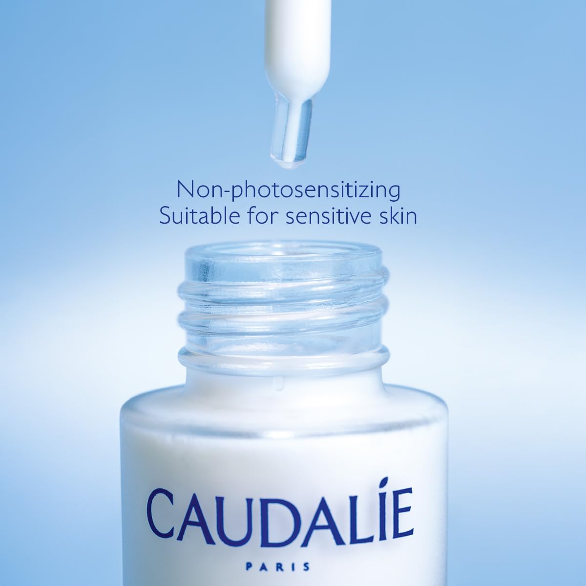 Sérum Caudalie Vinoperfect avec une fleur en arrière-plan
