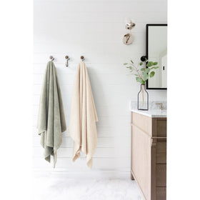 Serviette ROLSHOL pliée à côté de produits de beauté