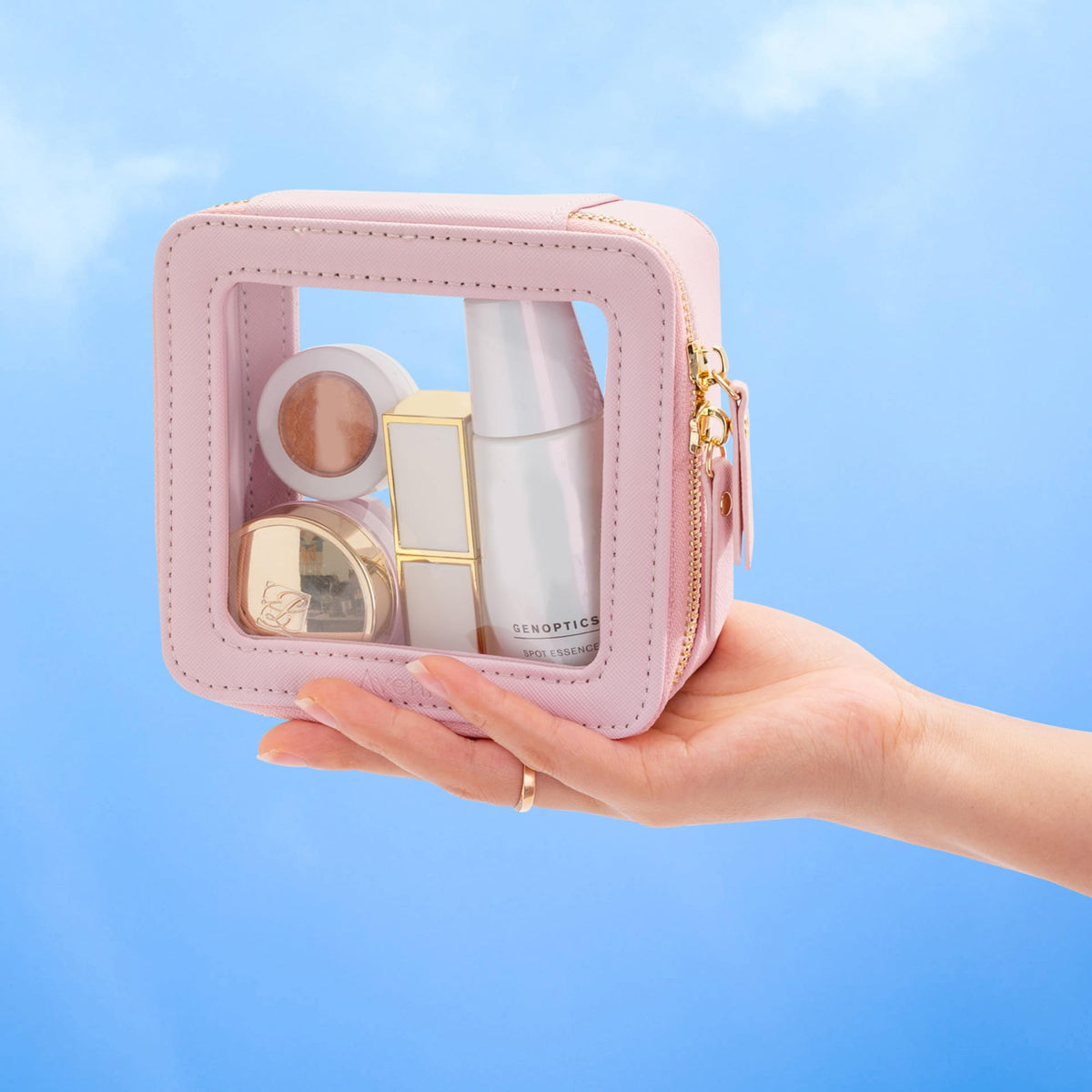 Trousse de maquillage Aveniee rose à côté d'une voiture avec accessoires