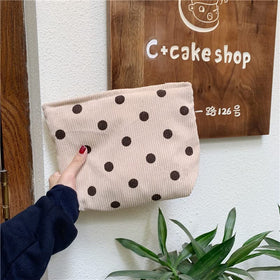 Trousse de maquillage PAZIMIIK beige à pois sur une table